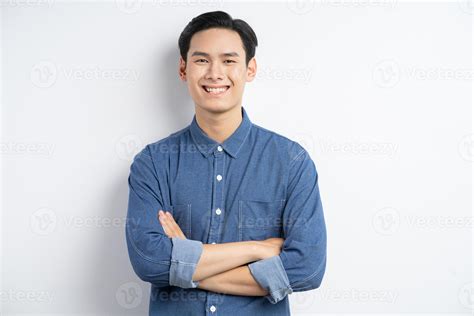 Photo Of An Asian Man Standing With His Arms Crossed And Smiling On A