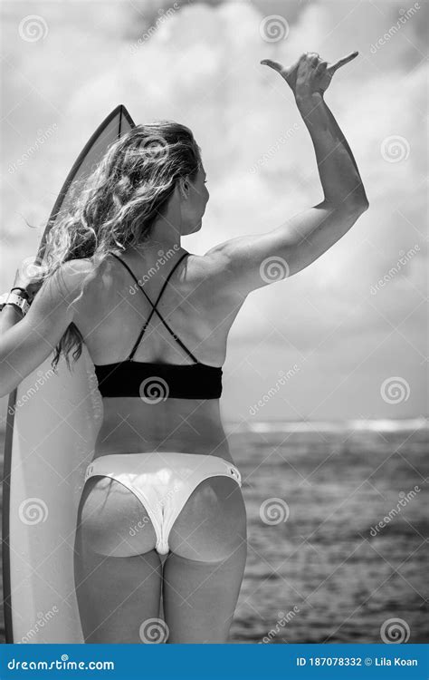 Mujer Joven En Bikini Con Tabla De Surf Por La Espalda Foto De Archivo