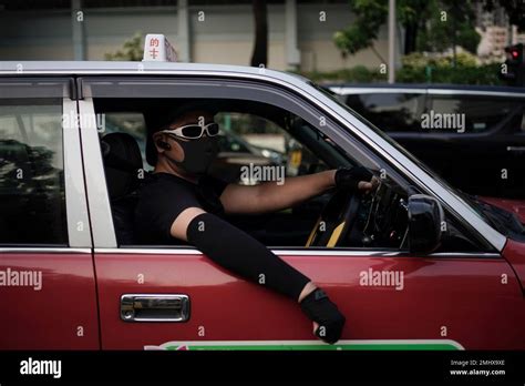 A taxi driver wears face mask looking out from his car during a protest