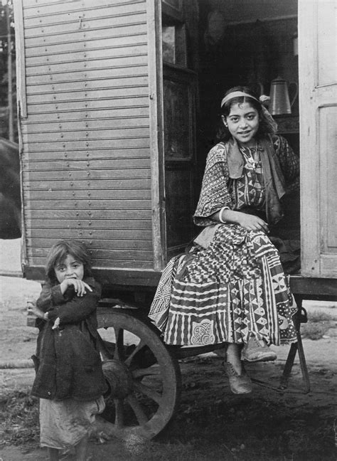 A Romani Girl Seated In Her Caravan Doorway With A Young Girl Standing