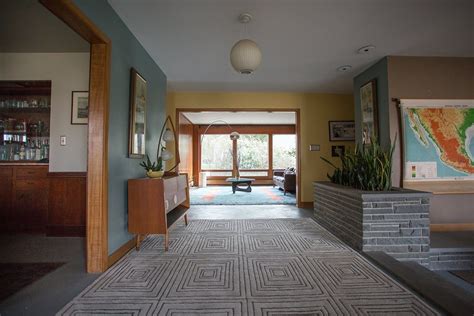 Wood elements, including the front door and horizontal slat siding across the side yard, add warmth and texture to the white brick facade. A Perfectly Preserved 1950s Ranch House | 1950s house ...