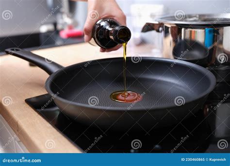 Chef Pouring Olive Oil Into Frying Pan In Kitchen Closeup Stock Image