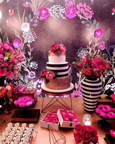A Table Topped With Pink Donuts And Flowers