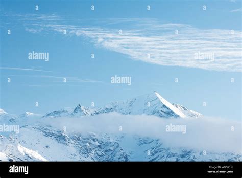Snow Capped Mountain Surrounded By Clouds Stock Photo Alamy