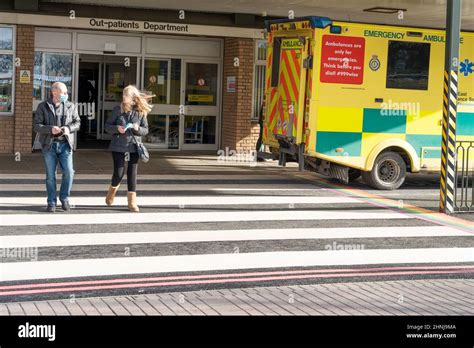 Two People Walk On The Zebra Crossing Outside The Outpatients