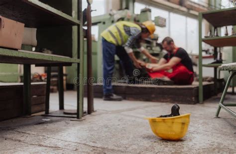 Woman Is Helping Her Colleague After Accident In Factory First Aid Support On Workplace Concept