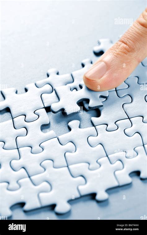 Finger Pushing Missing Puzzle Piece Into Place Stock Photo Alamy