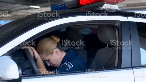 Exhausted Female Cop Officer In Police Car After Hard Work Day