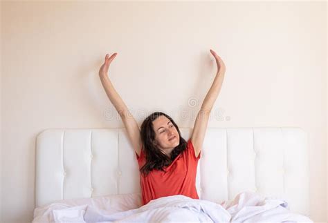 The Girl Sits On The Bed And Stretches The Woman Woke Up Stock Photo