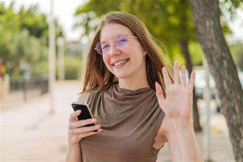 Premium Photo French Girl With Glasses Using Mobile Phone At Outdoors