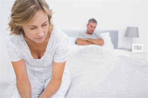 Couple Sitting On Opposite Ends Of Bed After A Fight Stock Image