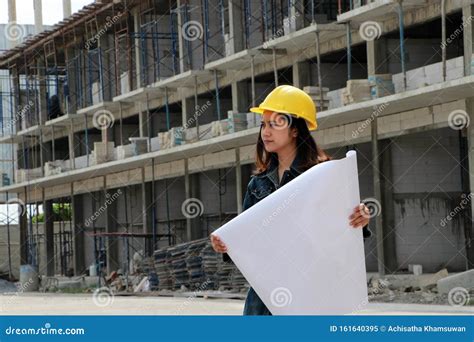 Female Civil Engineer Or Architect With Yellow Helmet Standing With