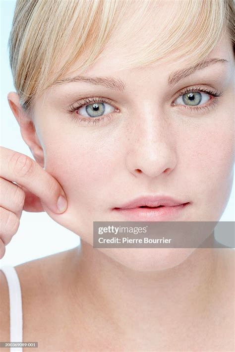 Young Woman Pinching Cheek Portrait Closeup High Res Stock Photo