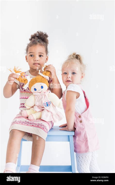Two Little Girls Playing On A White Background Stock Photo Alamy