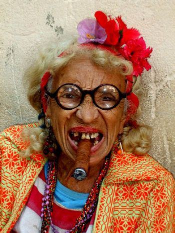 An Old Woman With Glasses And A Flower In Her Hair Is Making A Funny Face