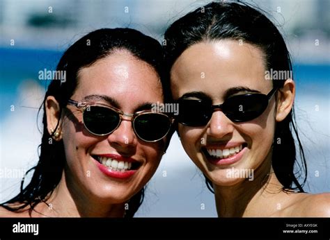 Two Young Brazilian Women Sporting Sunglasses And Beaming Smiles Pose