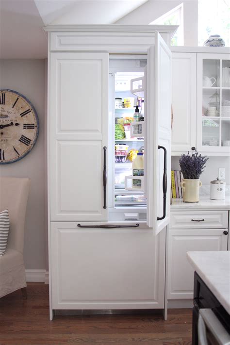 A White Refrigerator Freezer Sitting Inside Of A Kitchen Next To A