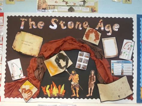 The Stone Age Bulletin Board Is Decorated With Paper And Pictures