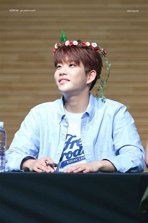 A Man Sitting At A Table With A Flower Crown On His Head And Water Bottle In Front Of Him