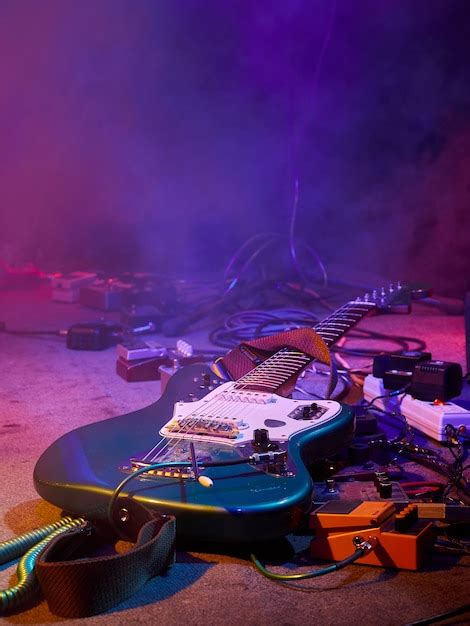 guitare et équipement de guitare se trouvent sur scène dans le brouillard et la fumée dans un