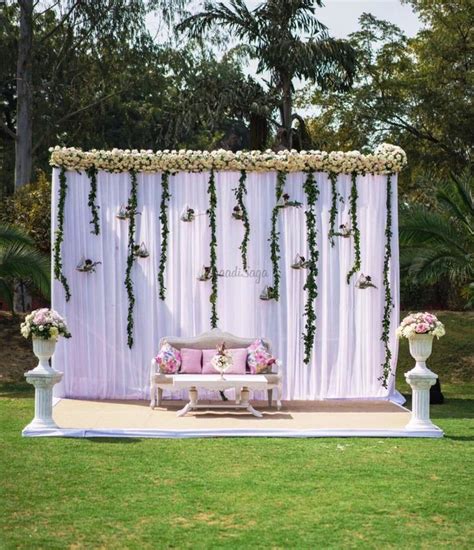 An Outdoor Ceremony Setup With Flowers And Greenery
