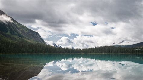 Panoramic Shot Of Pristine Alpine Lake Surrounded By Forest Stock Photo