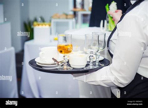 The Waiter Holding Tray With Dirty Dishes After Guests Of The Event