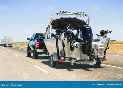 Semi Truck Towing A Boat On The Interstate California Stock Photo