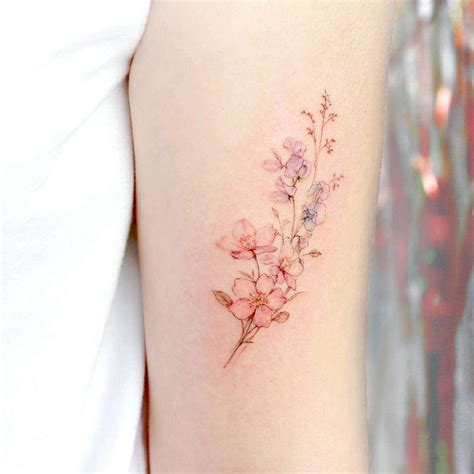 A Small Pink Flower Tattoo On The Right Arm And Shoulder With Delicate