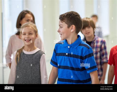 Group Of Smiling School Kids Walking In Corridor Stock Photo Alamy