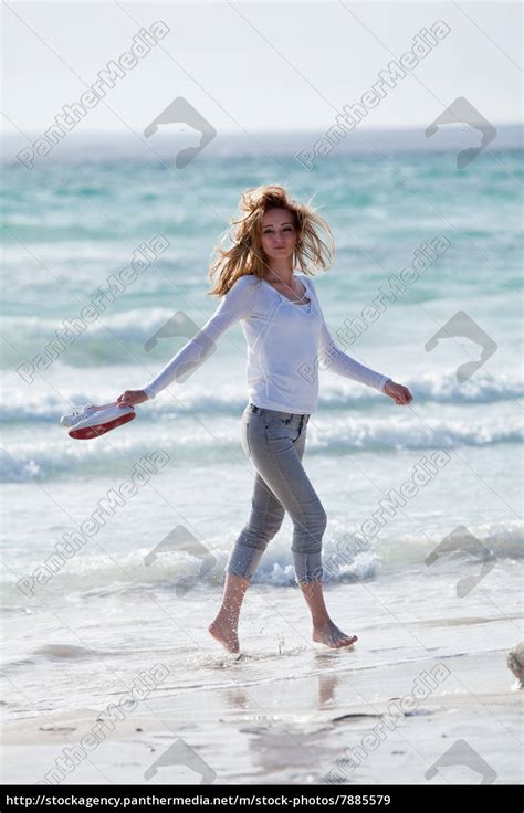 junge hübsche frau spaziert am strand im sand im Lizenzfreies Bild