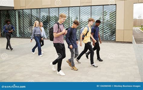 Group Of High School Students Walking Out Of College Building Together
