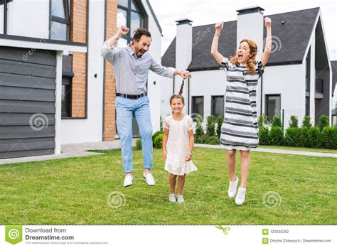 Joyful Positive Parents Jumping Stock Photo Image Of Cheerful Girl