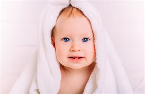 Premium Photo A Cute Baby With Blue Eyes Wrapped In A White Towel As