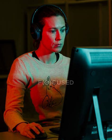 Portrait Of A Woman With Headphones Focused On A Desktop Computer