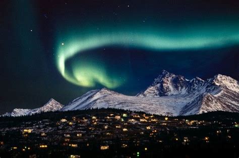 The Northern Lights Shine Brightly In The Night Sky Over Snowy