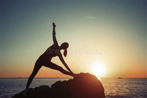 Yoga Woman Performs Morning Exercises On The Seaside In The Dawn Sport