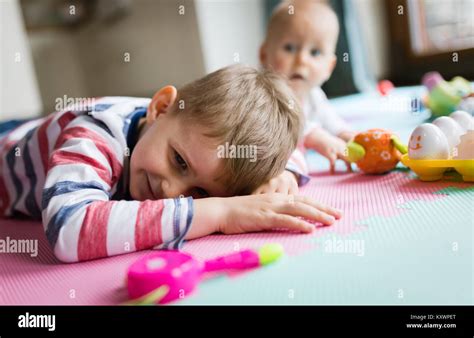 Cute Little Children Playing While Sitting On Carpet Stock Photo Alamy