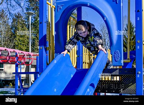Young Boy On Playground Slide Stock Photo Alamy