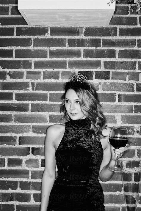 nye woman stands at party with wine glass del colaborador de stocksy sean locke stocksy