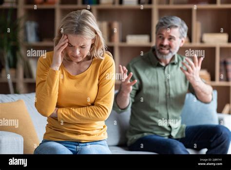 Psychological Abuse. Angry Middle Aged Husband Screaming At Upset Wife