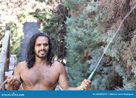 Muscular Shirtless Ethnic Man Opening Champagne Bottle Stock Photo