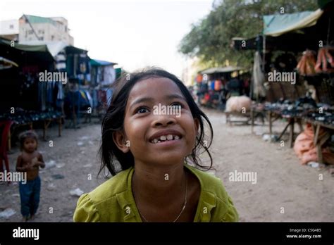 A Young Girl Living In Poverty Is Smiling Near Her Home In A Slum In