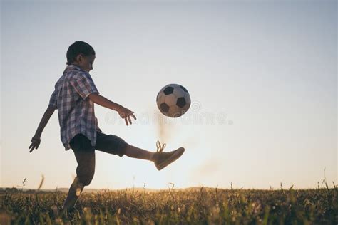 Young Little Boy Playing In The Field With Soccer Ball Stock Photo