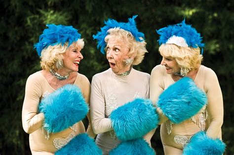 three women dressed in blue and white are laughing