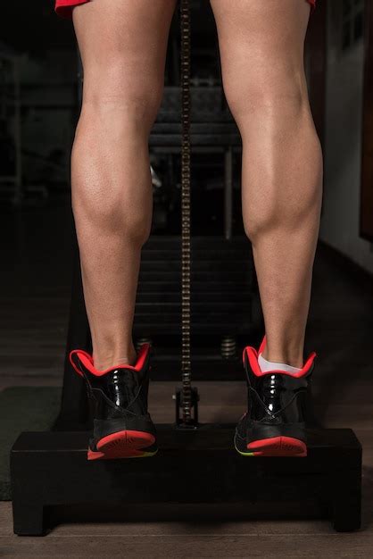 Premium Photo Bodybuilder Doing Heavy Weight Exercise For Legs Calves