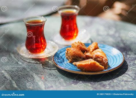 Turkish Tea Served In Tulip Shaped Glasses With Baklava Sweets In Cafe