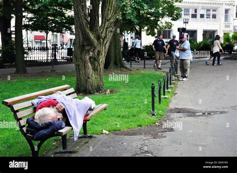 Homeless Man Sleeping On Bench In Park Boston Massachusetts USA