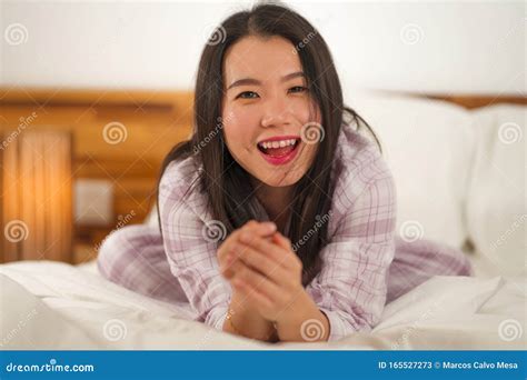 Lifestyle Portrait Of Young Beautiful And Sweet Asian Chinese Woman In Bed Feeling Happy And