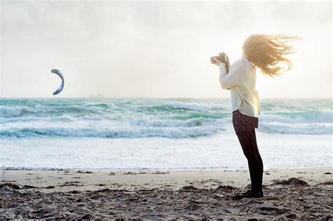 Teenage Girl Taking Photos At The Beach On A Windy Day By Angela Lumsden